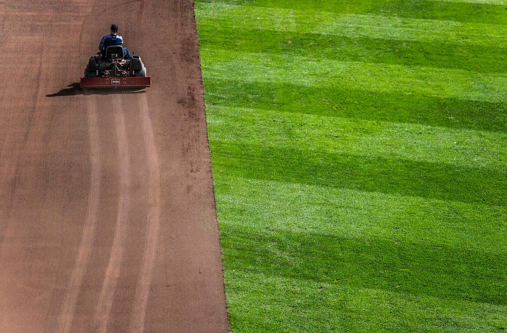 The grounds crew preps the field before the game during Opening Day at T-Mobile Park on March 28 in Seattle. (Olivia Vanni / The Herald)