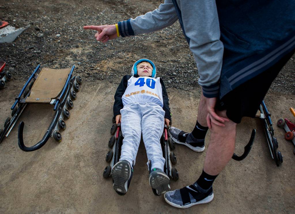 Caden Delaney squints as he learns how to steer from USA luger Adian Kelly during the USA Luge Silder Search program at Arrowhead Ranch on May 19 in Camano Island. (Olivia Vanni / The Herald)