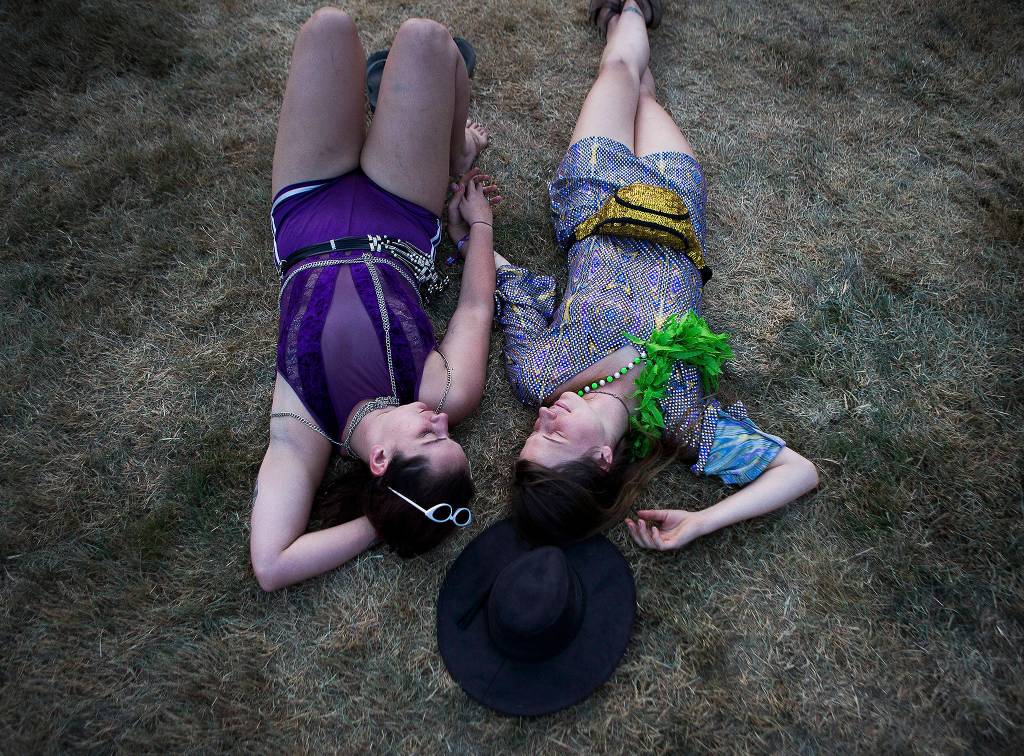 Xoe Heaney (left) and Sarah Bilchak (right) relax during the opening ceremony at the first day of Summer Meltdown on Aug. 1 in Darrington. (Olivia Vanni / The Herald)