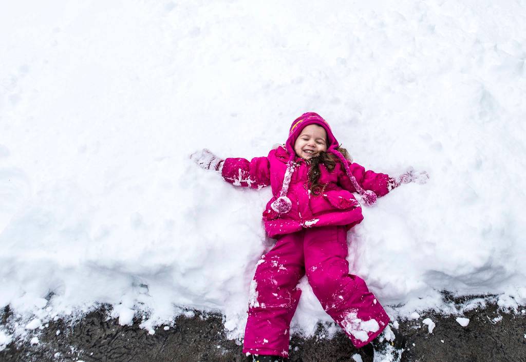 Kaylee Williams, 3, makes a snow angel on Feb. 9 in Everett. (Olivia Vanni / The Herald)