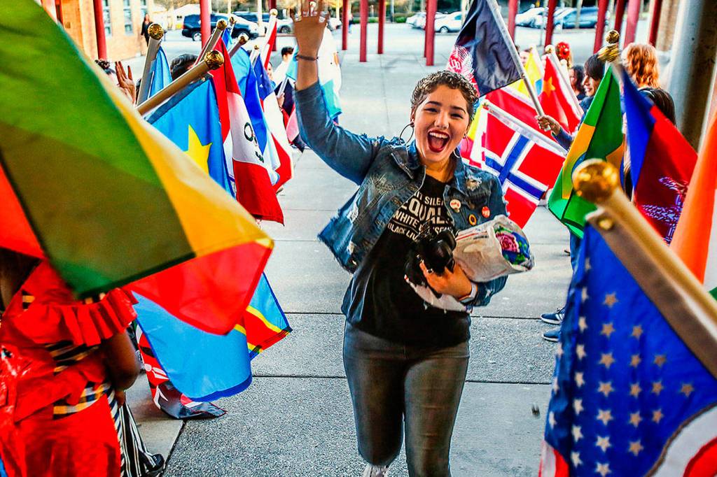 Senior Damilka Ortega runs past flag-waving students flanking the entryway to Cascade High School for the schools first Culture Night. (Dan Bates / The Herald)