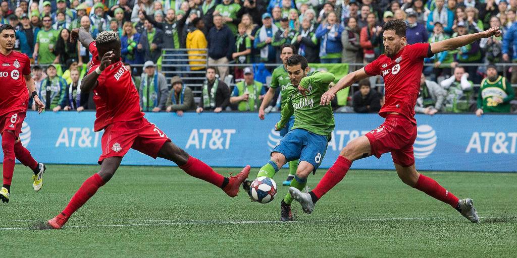 Sounders midfielder Víctor Rodríguez scores the second goal between two Toronto defenders as the Seattle Sounders beat Toronto FC 3-1 to win the MLS Cup on Nov. 10 in Seattle. (Andy Bronson / The Herald)