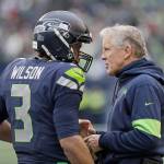 Seattle Seahawks head coach Pete Carroll talks with quarterback Russell Wilson during the first half of Sundays NFL game against the Arizona Cardinals. (AP Photo/Elaine Thompson)