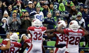Seattle Seahawks fans react as the Arizona Cardinals celebrate a fumble recovery by middle linebacker Jordan Hicks (lower left) in the second half of Sundays game in Seattle. (AP Photo/Lindsey Wasson)