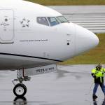A worker coils up the cord for a flight deck communications headset as a United Airlines Boeing 737 Max airplane prepares to take off Dec. 11 at Renton Municipal Airport. (AP Photo/Ted S. Warren)