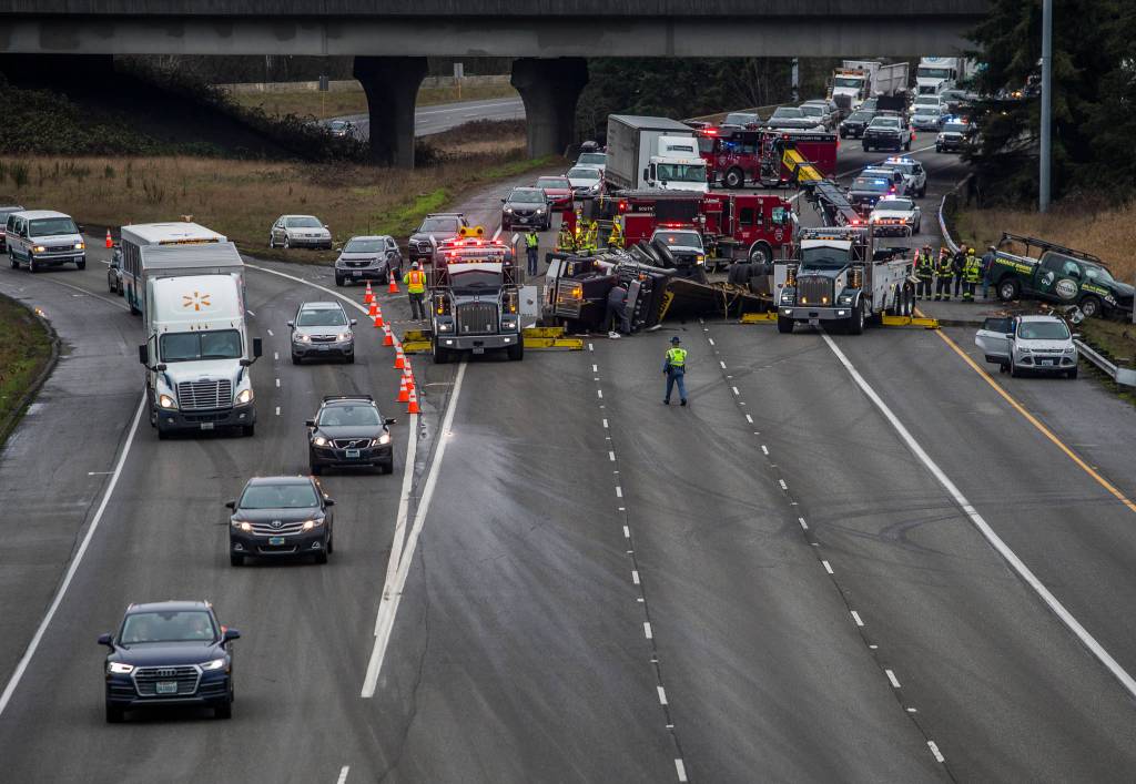 I-5 bound traffic from I-405 and northbound I-5 traffic merge together into one lane as firefighters and police work to clear a flipped semi blocking all northbound I-5 lanes on Thursday in Lynnwood. (Olivia Vanni / The Herald).
