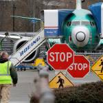 In this Dec. 16 photo, a Boeing worker walks in view of a 737 Max jet in Renton. (AP Photo/Elaine Thompson, File)