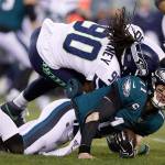 Seattle defensive end Jadeveon Clowney (90) hits Philadelphia quarterback Carson Wentz during the first half of their NFL wild-card playoff game Sunday in Philadelphia. Wentz was injured on the play. (AP Photo/Julio Cortez)