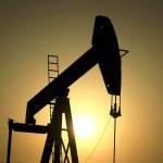 The sun sets behind an oil pump in the desert oil fields of Sakhir, Bahrain. The global benchmark for crude oil rose above $70 a barrel Monday for the first time in over three months, with jitters rising over the escalating military tensions between Iran and the United States. (AP Photo/Hasan Jamali, File)