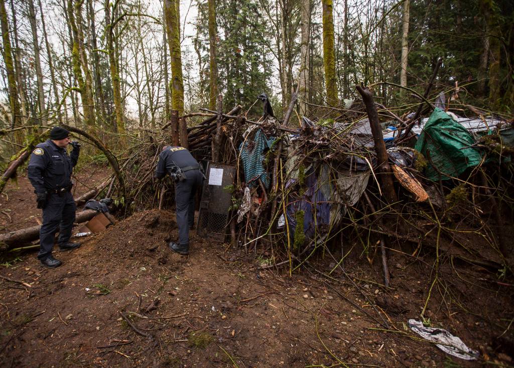 Sgt. Paul Ryan looks inside the dwelling as Officer Scott Kornish shines his light to ensure no one is inside Thursday in Monroe. (Olivia Vanni / The Herald)