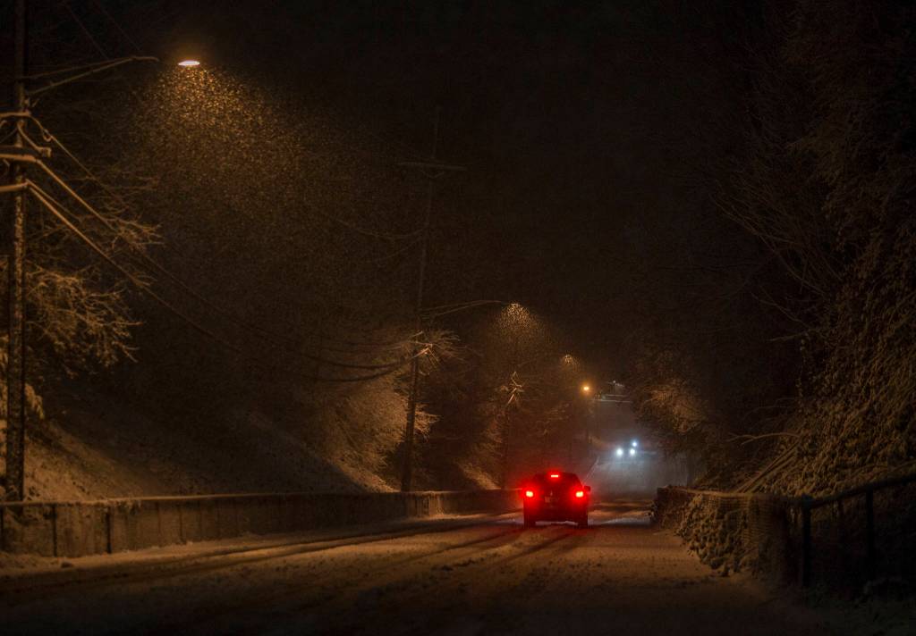 Cars drive slow up and down West Mukilteo Boulevard after earlier cars struggled while making their way up the hill on Sunday, Jan. 12, 2020 in Everett, Wash. (Olivia Vanni / The Herald).