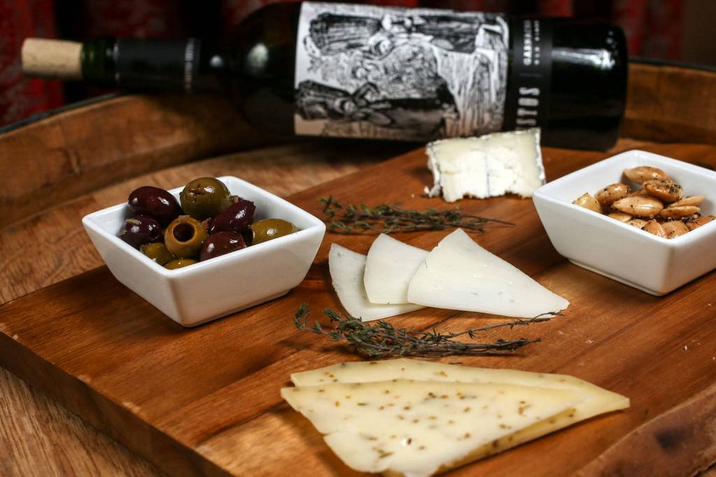 A goat and gouda cheese plate with marcona almonds and kalamata, picholine and cerignola olives, paired with Zestos granacha wine, is one of Greg Clauss favorite pairings. (Kevin Clark / The Herald)