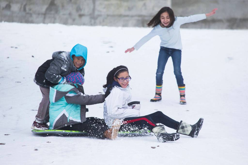 Andy Bronson / The Herald                                Milah Redding (right) tries to keep her balance after trying to jump on a sled with friends Julian Guzman, Peyton Donovan, and Sofia Guzman in Arlington on Tuesday.                                Milah Redding, right, tries to keep her balance after trying to jump on a sled with friends, Julian Guzman, Peyton Donovan, and Sofia Guzman on Tuesday, Jan. 14, 2020 in Arlington, Wash. (Andy Bronson / The Herald)