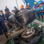 In this Nov. 4, 2018 photo, rescuers inspect part of the landing gear of the crashed Lion Air jet retrieved from the sea floor in the waters of Tanjung Karawang, Indonesia. (AP Photo/Fauzy Chaniago, file)