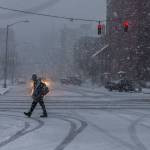 A man walks through downtown Everett as snow begins to fall heavily on Wednesday in Everett. (Olivia Vanni / The Herald)