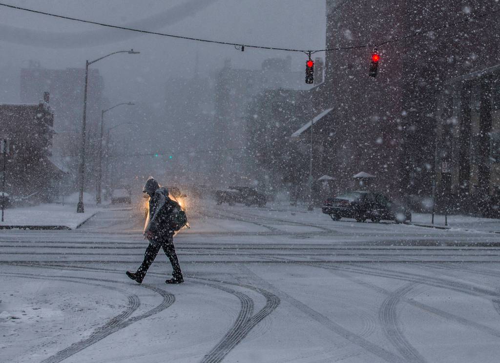 A man walks through downtown Everett as snow begins to fall heavily on Wednesday in Everett. (Olivia Vanni / The Herald)