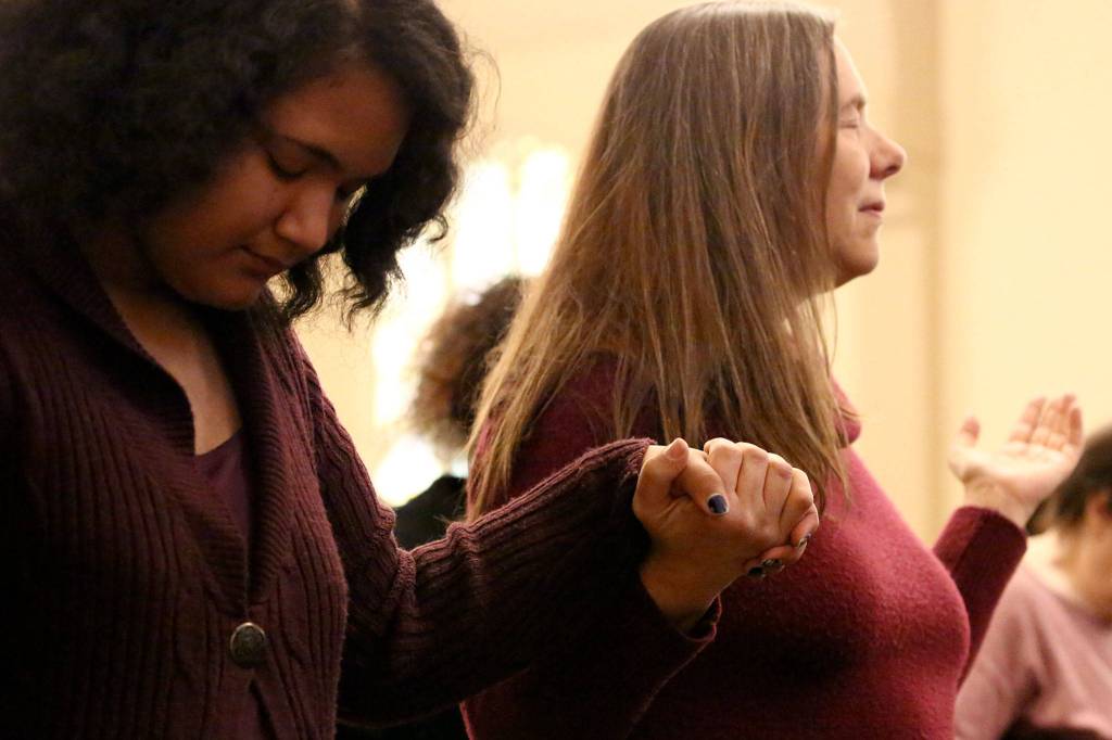 Aviahna Harrell (left) and Diane Young pray during the Martin Luther King Jr. celebration Sunday afternoon at First Presbyterian Church in Everett. (Kevin Clark / The Herald)