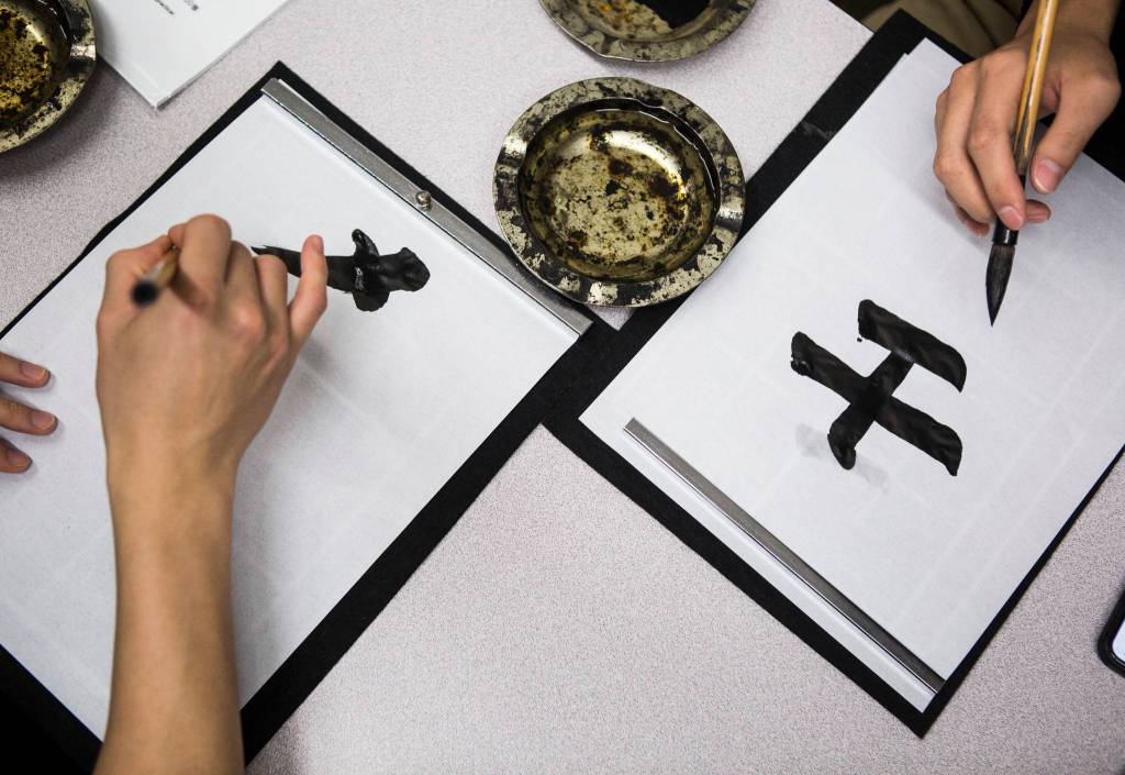 People practice shodo at a station set up for the ceremony on Jan. 24 in Everett. (Olivia Vanni / The Herald)