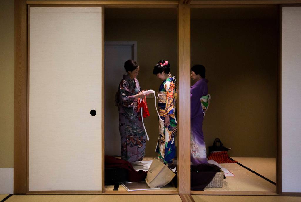 Mariko Kayama (left) and Yu Ugawa fit Kotoko Miyamae for a kimono on Jan. 24 in Everett. (Olivia Vanni / The Herald)
