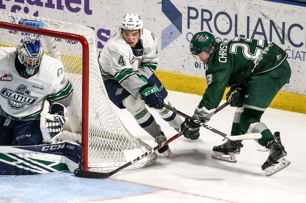 Silvertips Jake Christiansen shoots with Seattles Zach Ashton (center) defending and Roddy Rodd goaltending Sunday evening at the ShoWare Center in Kent. (Kevin Clark / The Herald)