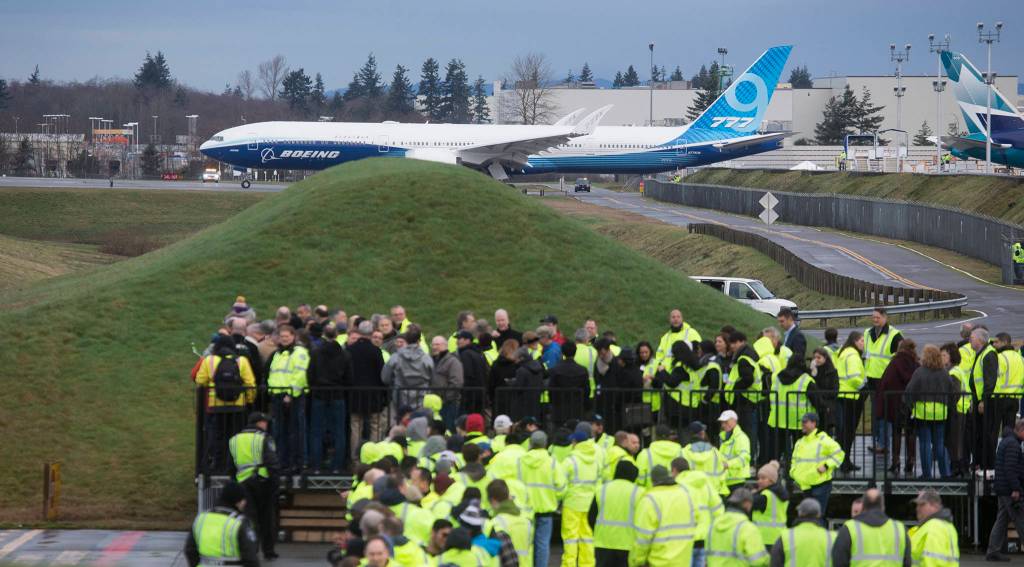 Boeing employees watch the 777X taxi for takeoff from Paine Field for its first flight on Saturday in Everett. (Andy Bronson / The Herald)
