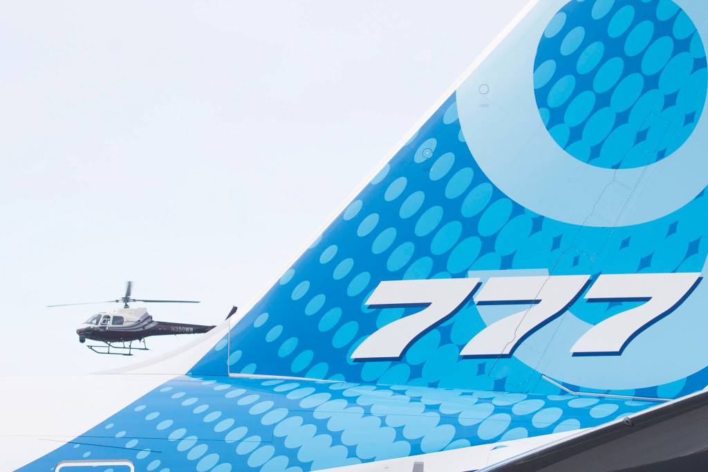 A helicopter follows as Boeings 777X taxies before takeoff from Paine Field on its first flight, to Boeing Field in Seattle, on Saturday, Jan. 25, 2020 in Everett, Wash. (Andy Bronson / The Herald)