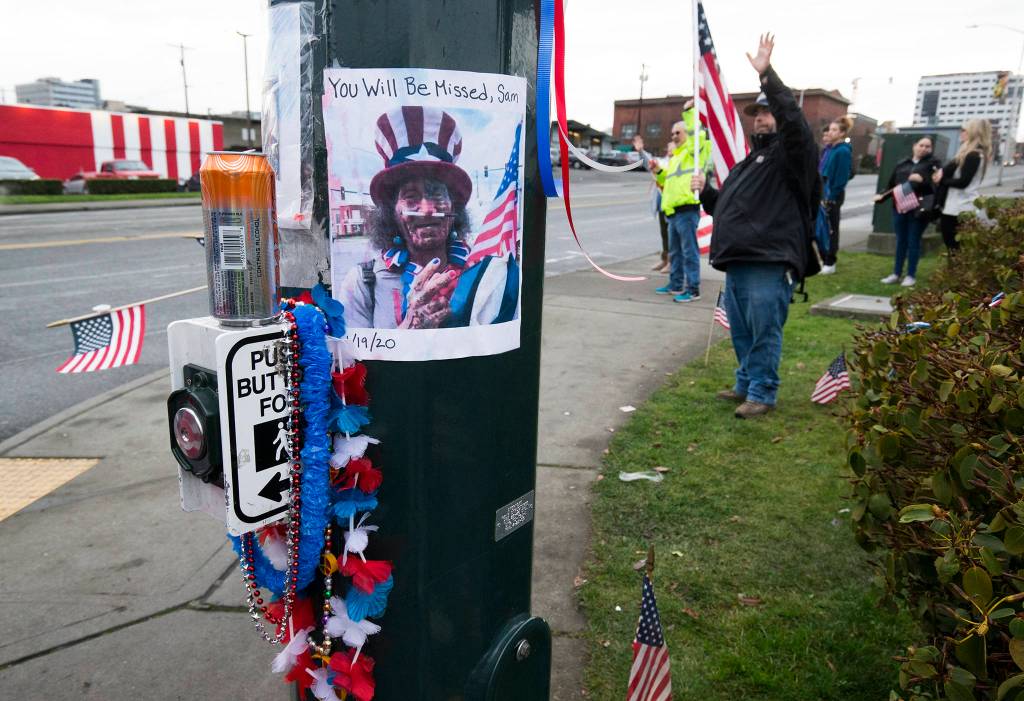A photo of Samiu Bloomfield is taped to a pole where his friends and fans gather on Broadway to wave in his honor Monday in Everett. (Andy Bronson / The Herald)