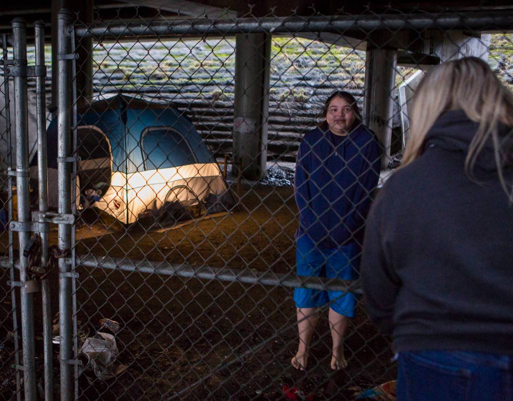 Snohomish County social worker Amanda Jeffcott talks with two people living in an area known as The Bat Caves on Thursday. (Olivia Vanni / The Herald)