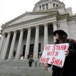 Petty Hutt of Gig Harbor holds a sign that reads, We Stand With Matt Shea, as she attends a rally Jan. 13 at the Capitol in Olympia. (AP Photo/Ted S. Warren)