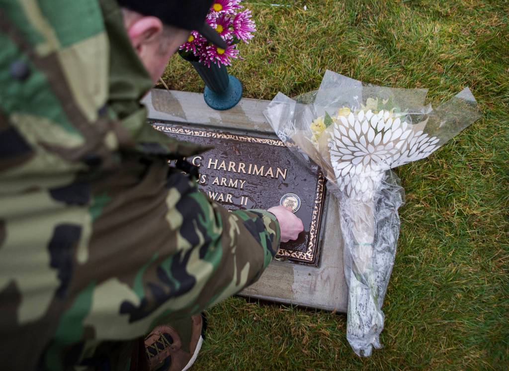 Snoqualmie Tribe treasurer Chris Castleberry places a Native Veteran medallion on Joseph Harrimans headstone on Saturday, Jan. 25, 2020 in Monroe, Wash. The World War II veteran died in 1950. His grave site went unmarked for 70 years. (Olivia Vanni / The Herald)