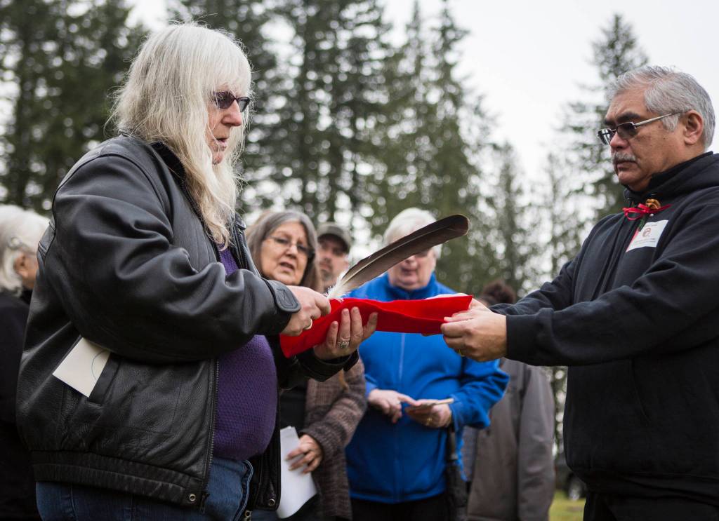 Pat Fitchen, left, receives an eagle feather for Snoqualmie Tribe chairman Bob De Los Angles to honor Joseph Harrimans strength and bravery on Saturday, Jan. 25, 2020 in Monroe, Wash. After 70 years, the World War II veteran now has a grave marker, one that recognizes his military service. (Olivia Vanni / The Herald)