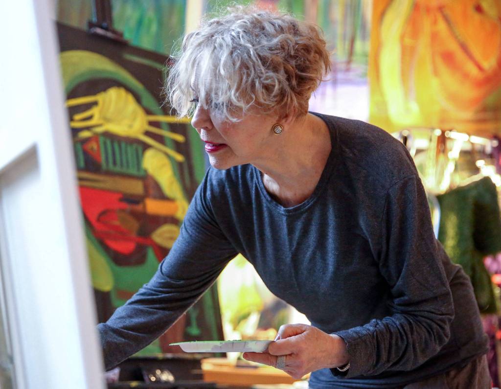 Solveig GiGi Sundhagen paints at her home at Artspace Everett Lofts. (Kevin Clark / The Herald)