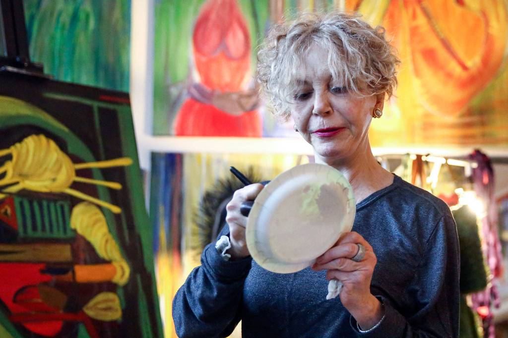 Solveig GiGi Sundhagen prefers a paper plate over the more traditional painters palette. (Kevin Clark / The Herald)