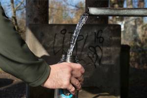 A man fills a water bottle at an artesian well in Lynnwood. (Andy Bronson / Herald file)
