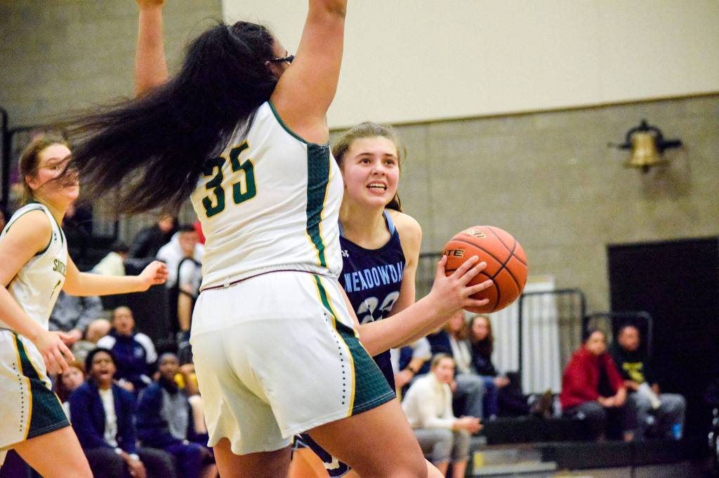 Meadowdales Ava Powell (right) looks up to shoot a basket against Shorecrests Kiana Lino on Thursday, Jan. 30 at Shorecrest High School in Shoreline. (Katie Webber / The Herald)