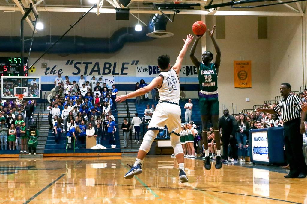 Edmonds-Woodways Mutdung Bol attempts a 3-pointer with Meadowdales Colton Walsh defending Friday evening at Meadowdale High School in Lynnwood January 24, 2019. (Kevin Clark / The Herald)
