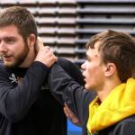 Darrington assistant coach Mason McKenzie (left) works with Nik Requa (right) during practice Feb. 6 at Darrington High School. (Kevin Clark / The Herald)