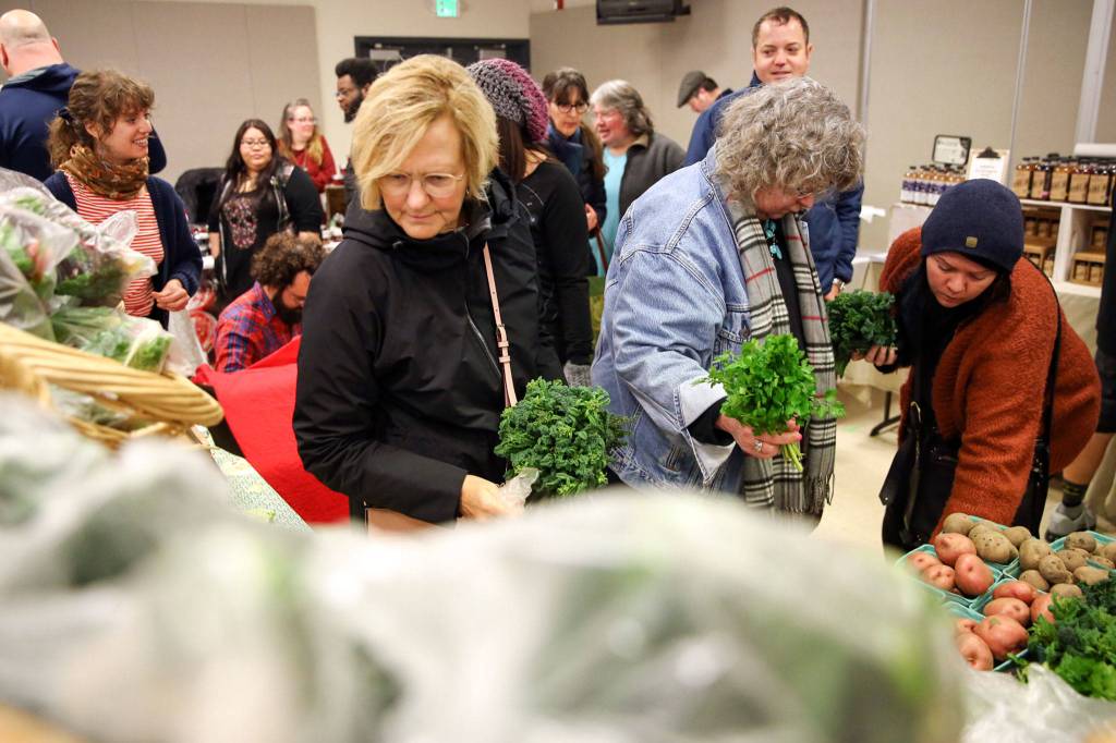 Markets goers browse produce Sunday morning at the Popup Market at Village Theatre in Everett on February 9, 2020. (Kevin Clark / The Herald)