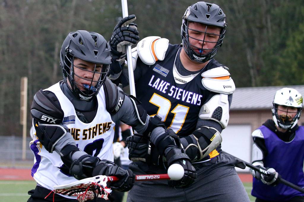 Lake Stevens Micah Close and Talen Anderson battle for a loose ball during a boys lacrosse practice at Cavalero Mid High School on Dec. 8, 2019 in Lake Stevens. (Kevin Clark / The Herald)