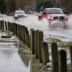 A truck drives through water running over Highway 530 on Saturday next to Twin Rivers County Park in Arlington. More heavy rain is expected this week, with increased flood risk. (Olivia Vanni / Herald file)