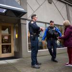Everett Police Officers Kevin Davis (left) and Mike Bernardi chat with Kathy White as they walk through downtown Everett on Thursday. (Olivia Vanni / The Herald)