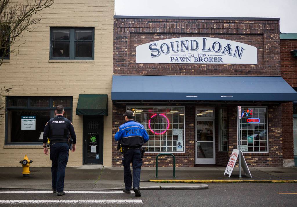 Everett Police Officers Kevin Davis (left) and Mike Bernardi cross Wetmore Avenue on Thursday. (Olivia Vanni / The Herald)