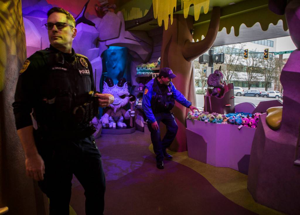 Everett Police Officers Kevin Davis (left) and Mike Bernardi stop by Funko on Thursday during a walking patrol of downtown. (Olivia Vanni / The Herald)
