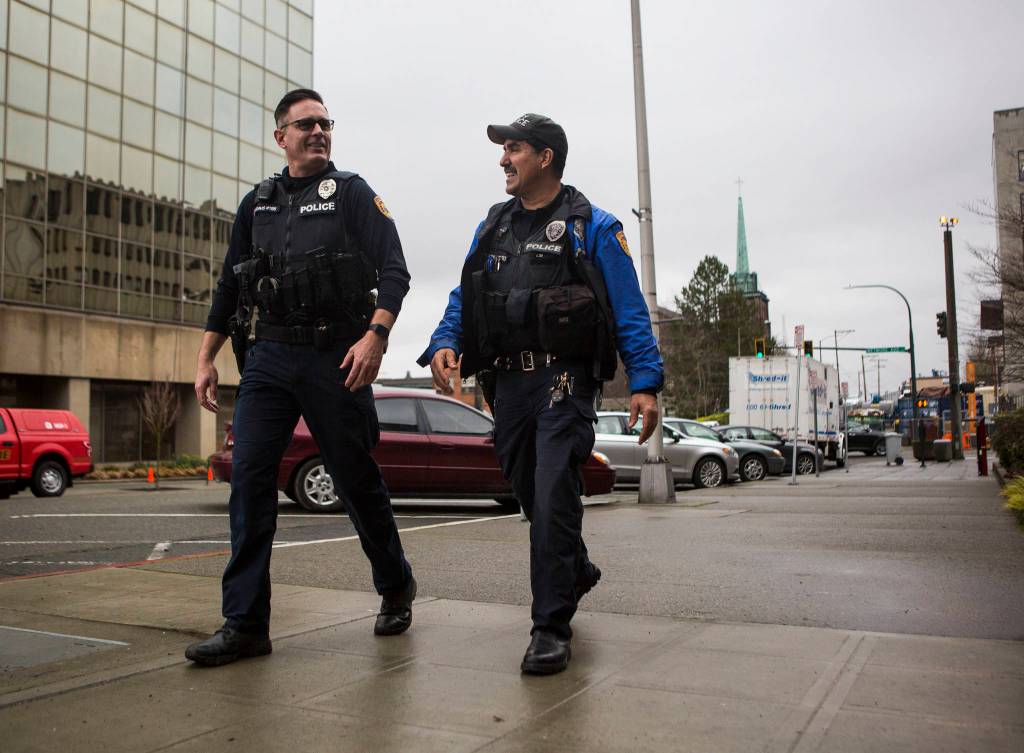 Everett Police Officers Kevin Davis (left) and Mike Bernardi stroll through downtown Thursday. (Olivia Vanni / The Herald)