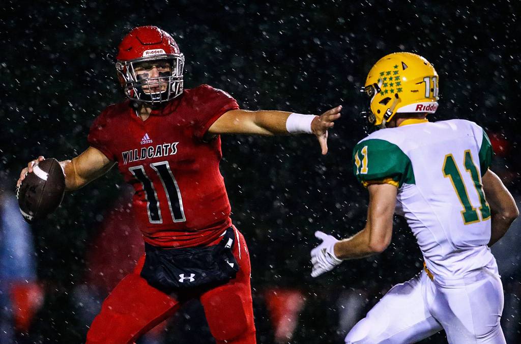 Archbishop Murphys Victor Gabalis (left) is chased out of the pocket by Lyndens Elijah Lyons during a game on Sept. 27, 2019, at Archbishop Murphy High School in Everett. (Kevin Clark / The Herald)