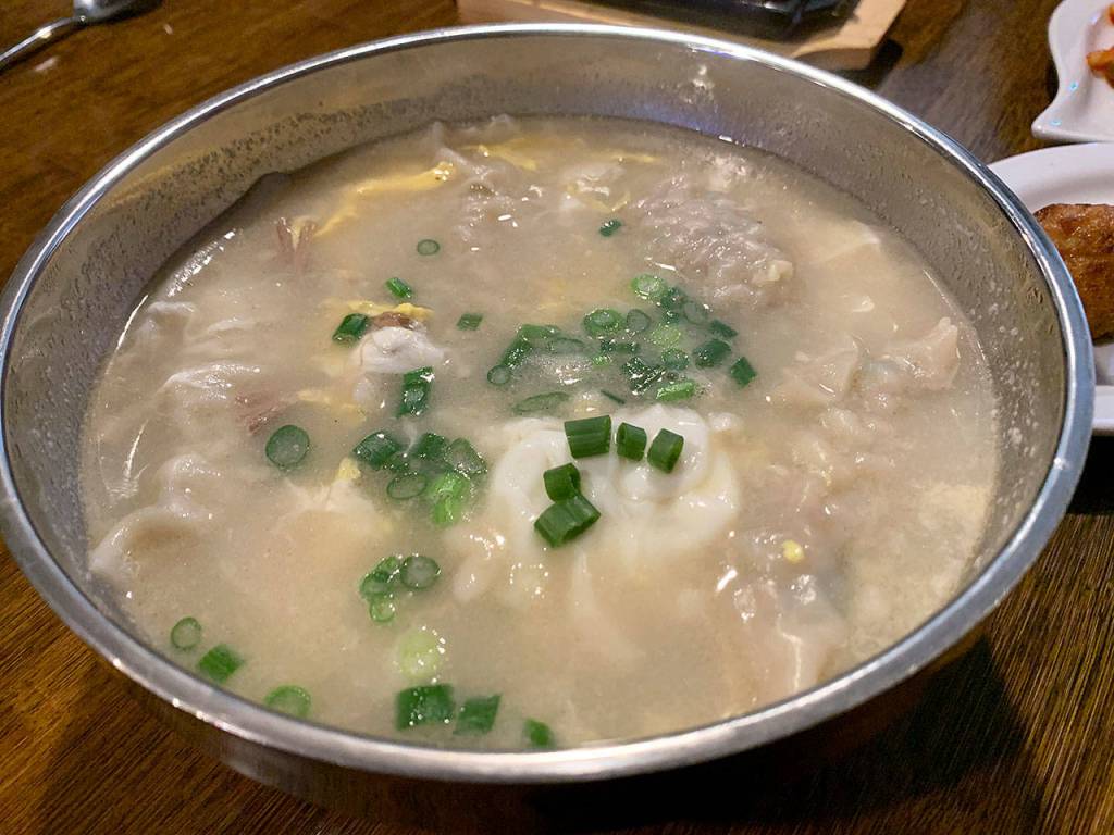 Modoos dumpling soup comes with rice cakes, eggs, green onions and pork-filled dumplings. (Evan Thompson / The Herald)