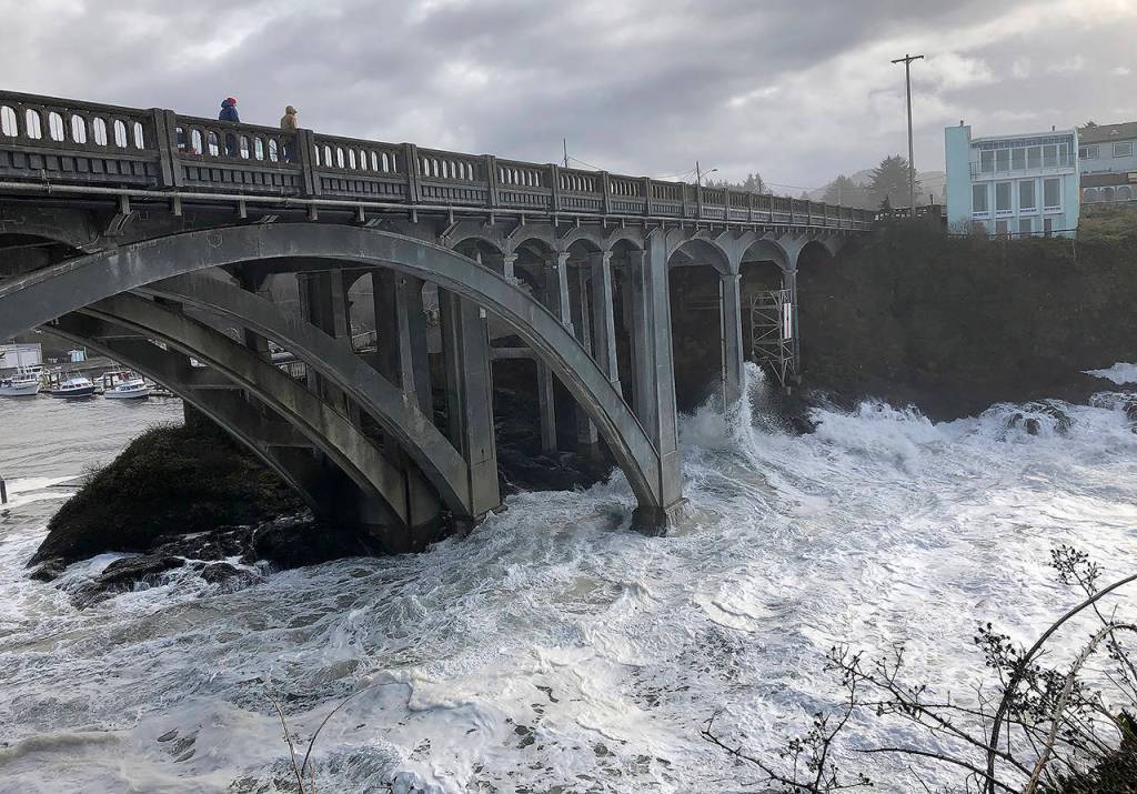 In this Jan. 11 photo, heavy surf surrounds the legs of a bridge as an extreme high tide rolls into the harbor in Depoe Bay, Oregon during a so-called king tide that coincided with a big winter storm. (AP Photo/Gillian Flaccus)