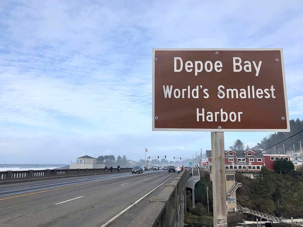 In this Jan. 11 photo, a sign marks the entry to Depoe Bay, Oregon during an extreme high tide that coincided with a big winter storm. (AP Photo/Gillian Flaccus)