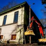 Outside the Snohomish Carnegie Library, contractor Rob Enge (left) attaches a chain to a roll of heavy cable as Kody Brooks approaches to help carry it with a tractor Tuesday at one side of the original building as it begins to look more and more like it did before an annex was added in the 1960s. (Dan Bates / The Herald)