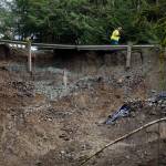 A Geotechnical Testing Inspections worker surveys the slide site off of Ben Howard Road on Monday in Monroe. (Olivia Vanni / The Herald)